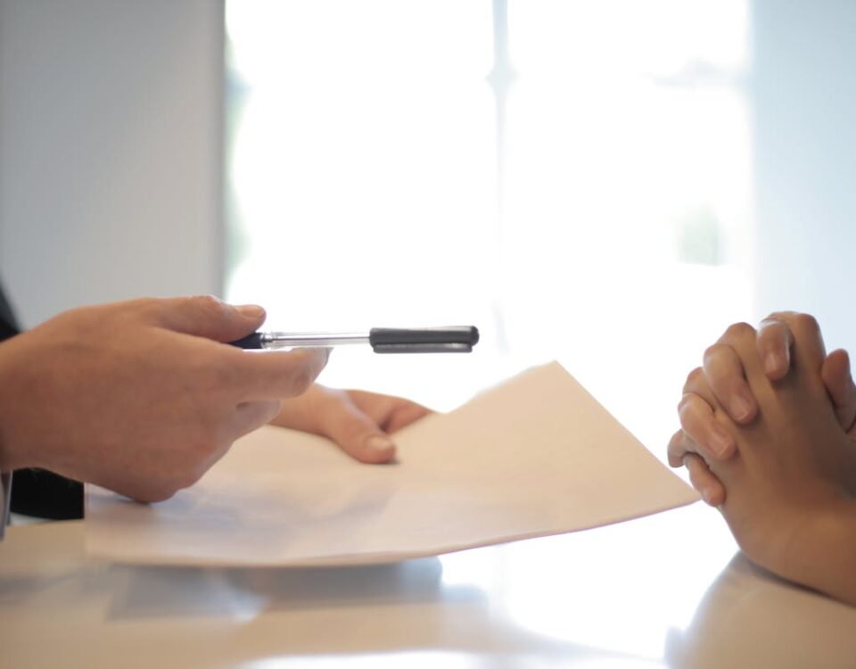 Crop businessman giving contract to woman to sign