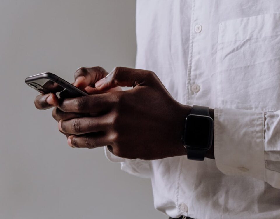 Person in White Dress Shirt Holding Black Smartphone