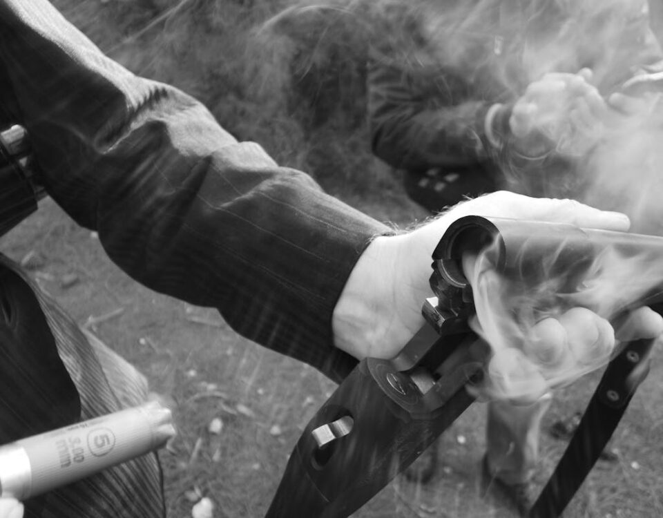 O que diz a lei sobre a posse de armas no Brasil? Detailed shot of a hand holding a smoking shotgun, highlighting the action and movement.