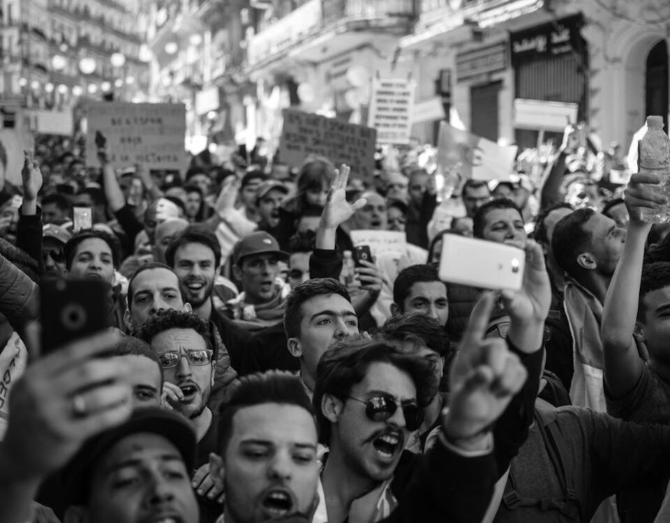 Políticas públicas e direitos do cidadão: o que saber Crowded Algerian street protest captured with intensity and detail.