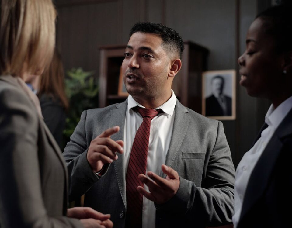 Diferenças entre advogado criminalista e advogado comum Diverse group of business professionals in suits having an engaging discussion in an office setting.