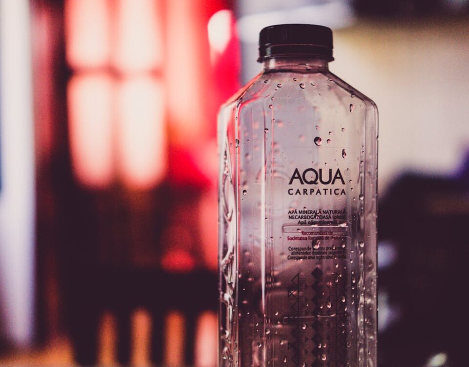 Detailed view of an Aqua Carpatica water bottle with droplets and blurred background.