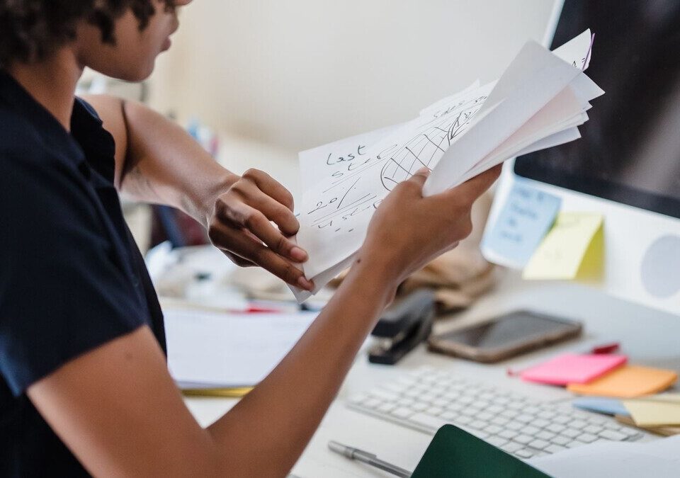 Mulher analisando documentos em mesa de escritório