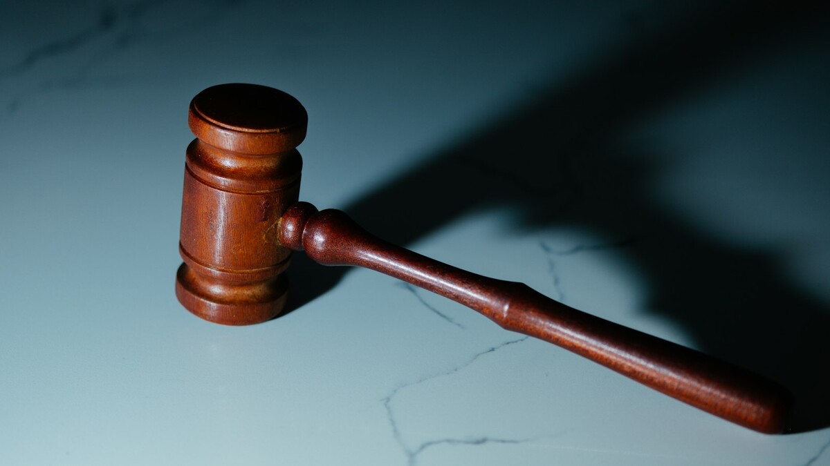 Bet não pagou ou bloqueou saque? Quais direitos o apostador tem Martelo de juiz de madeira sobre uma mesa