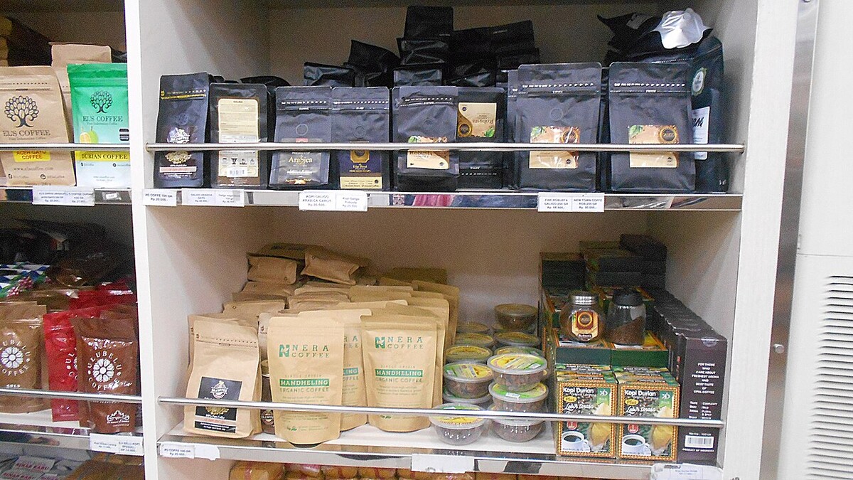 Café artesanal online: o que o rótulo precisa informar? Prateleiras de loja com vários pacotes de café de diferentes marcas