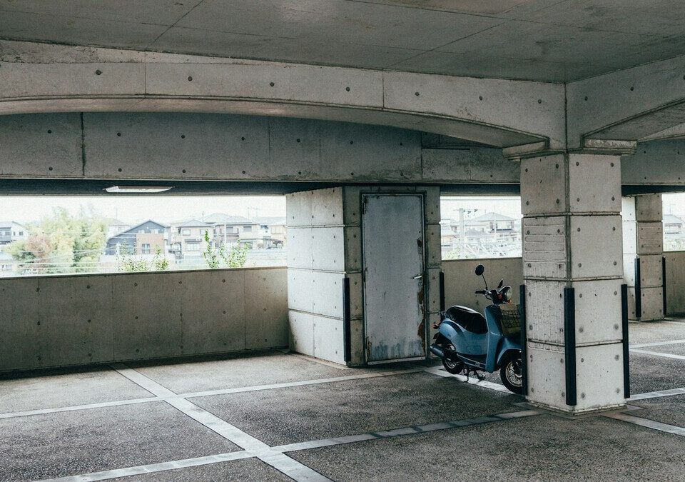 Moto estacionada em garagem coberta de concreto