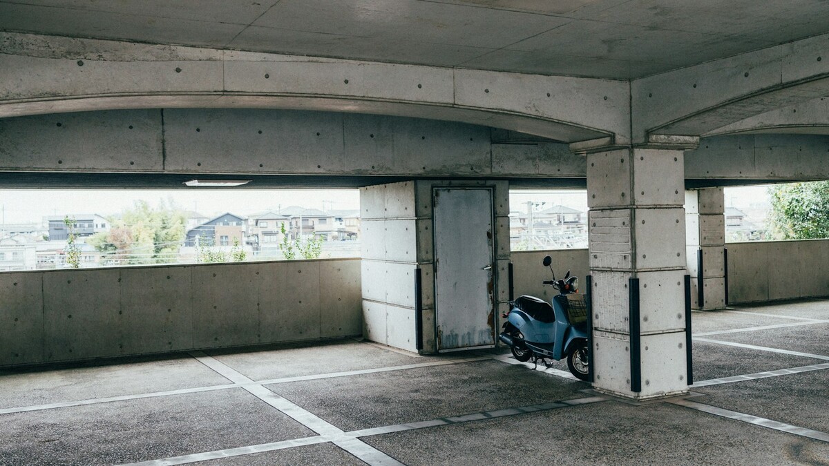 Moto estacionada em garagem coberta de concreto