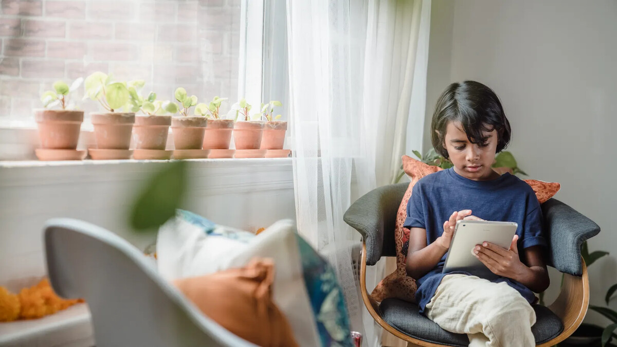 Criança utilizando tablet em ambiente doméstico