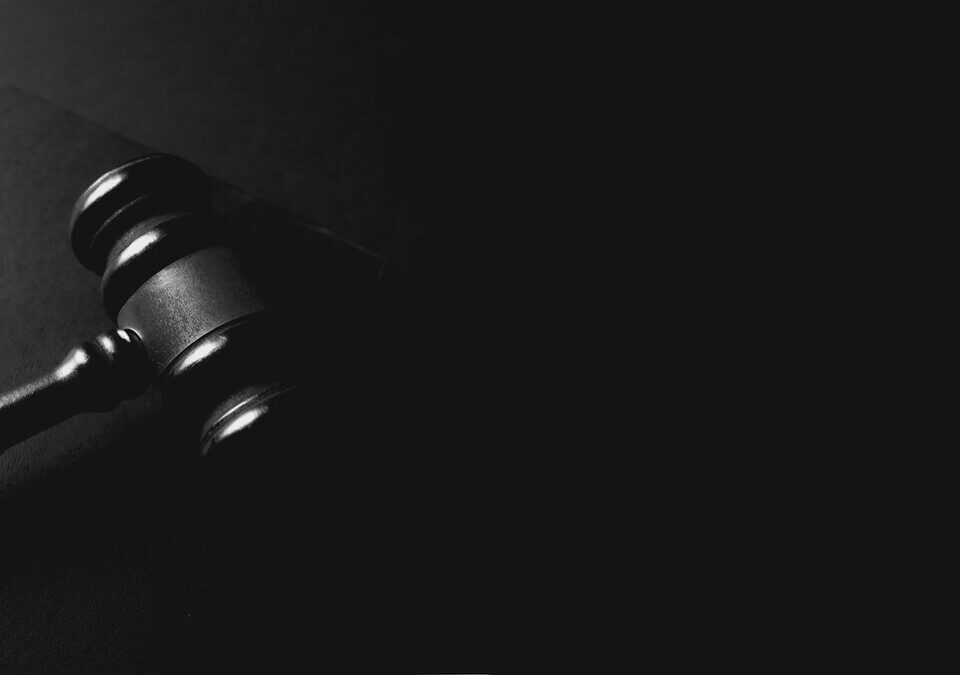Martelo de juiz preto sobre uma superfície escura