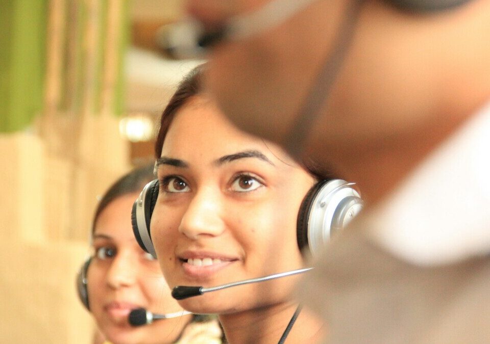 Duas pessoas usando headsets em um escritório