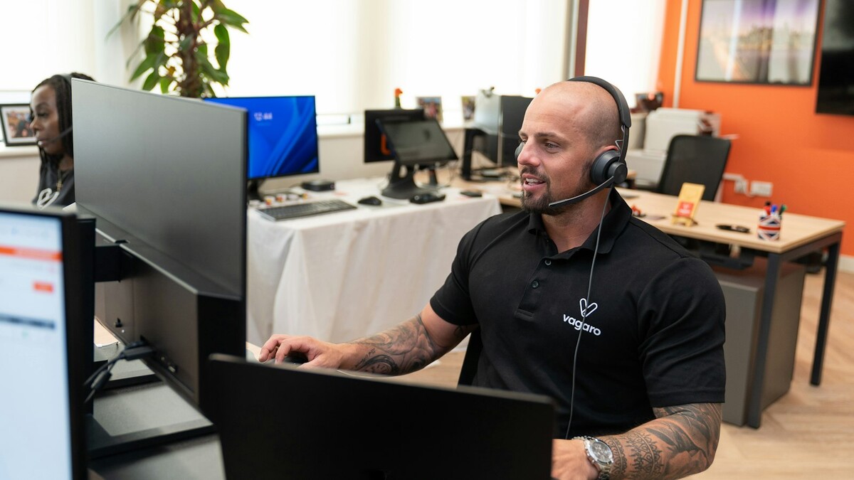 Atendente com headset diante de um computador