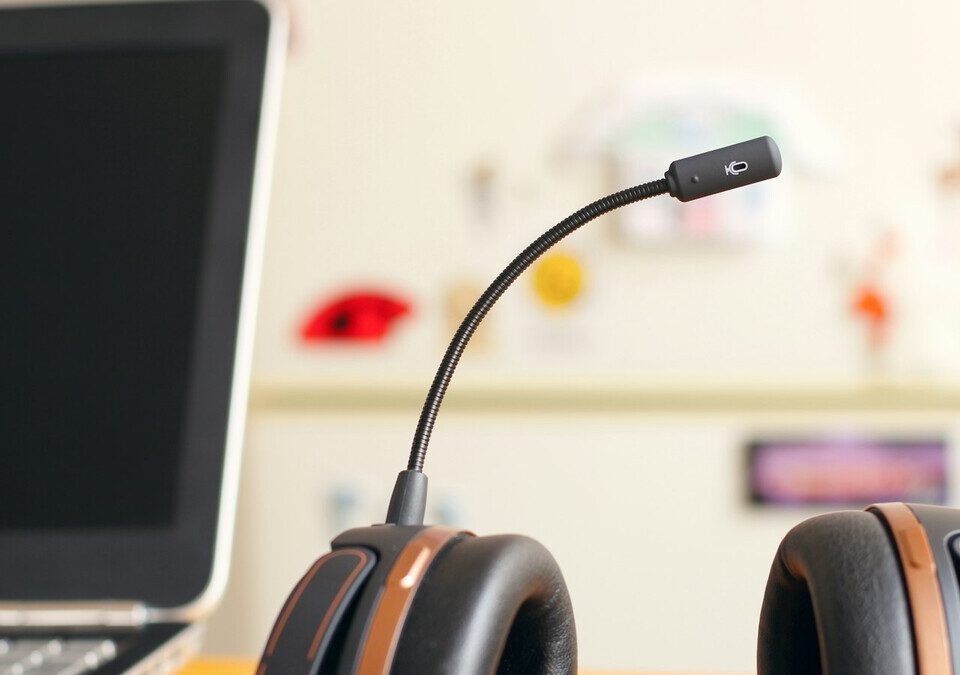Headset de atendimento ao lado de um notebook