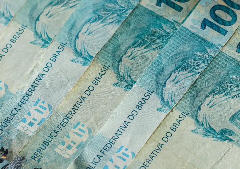 Cédulas de 100 reais espalhadas sobre uma superfície