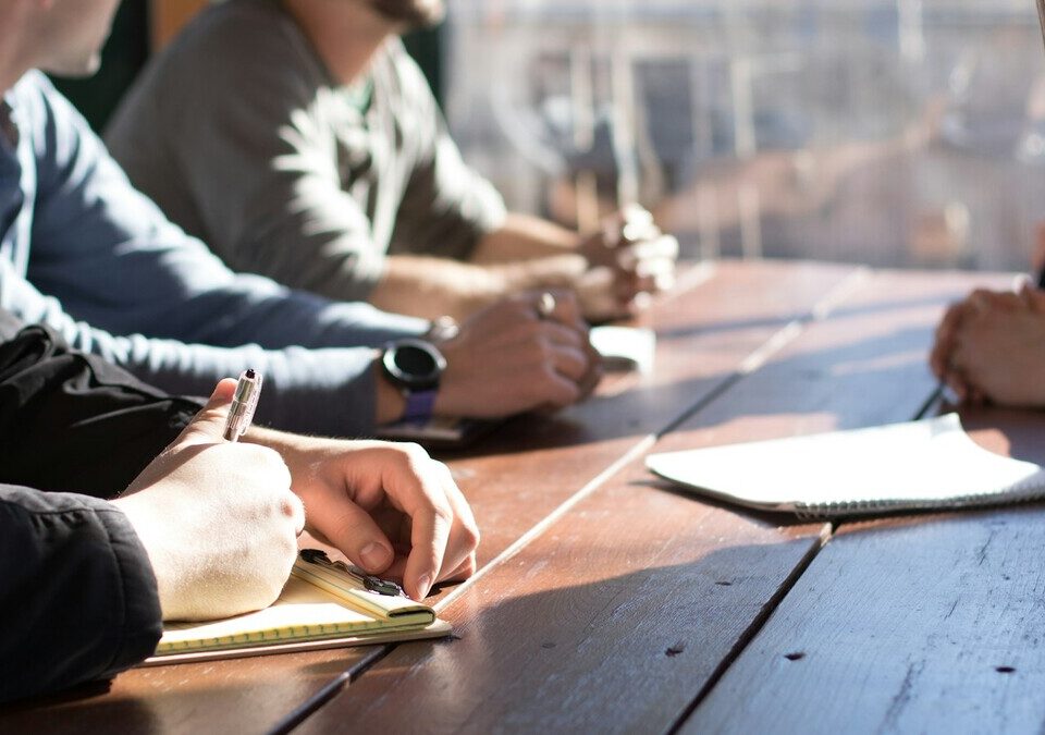 Equipe reunida ao redor de uma mesa durante um treinamento